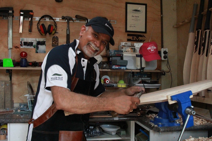 Shashi smiles while making a cricket bat.