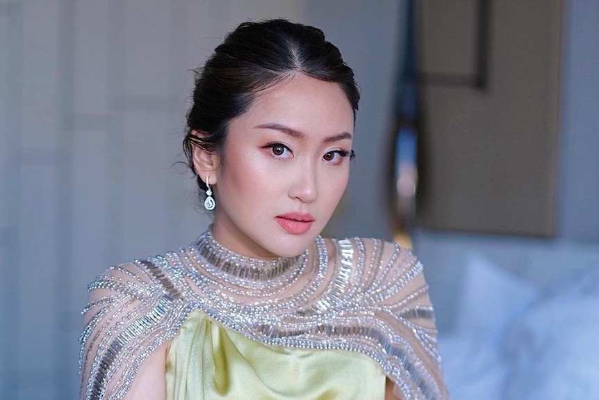 A young Thai woman in a yellow bejewelled dress 