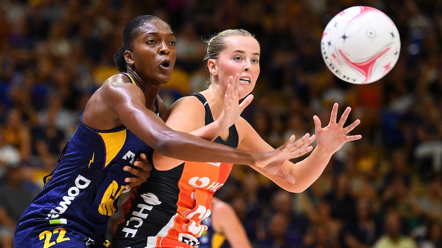 A Lightning Super Netball player and a Giants opponent compete for the ball.