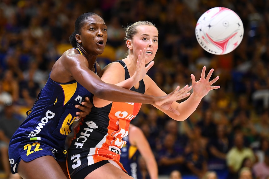 A Lightning Super Netball player and a Giants opponent compete for the ball.