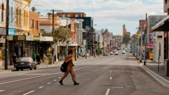 A person crosses an empty street in Melbourne