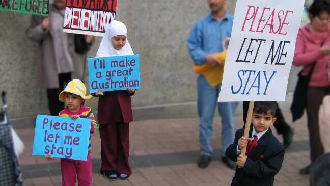 Refugee children hold placards reading 'Please let me stay' (Pamela Curr)
