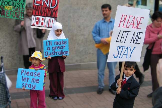 Refugee children hold placards reading 'Please let me stay' (Pamela Curr)