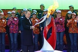 Vladimir Putin holds a lighted Olympic torch