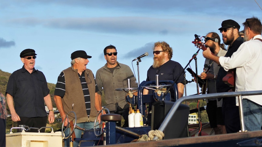 A group of male singers on stage performing.