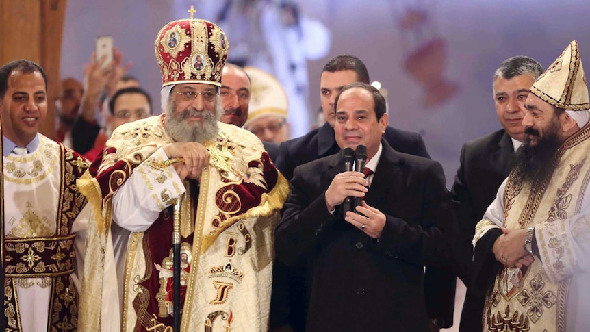Egyptian President Abdel Fattah al-Sisi talks next to Coptic Pope Tawadros II