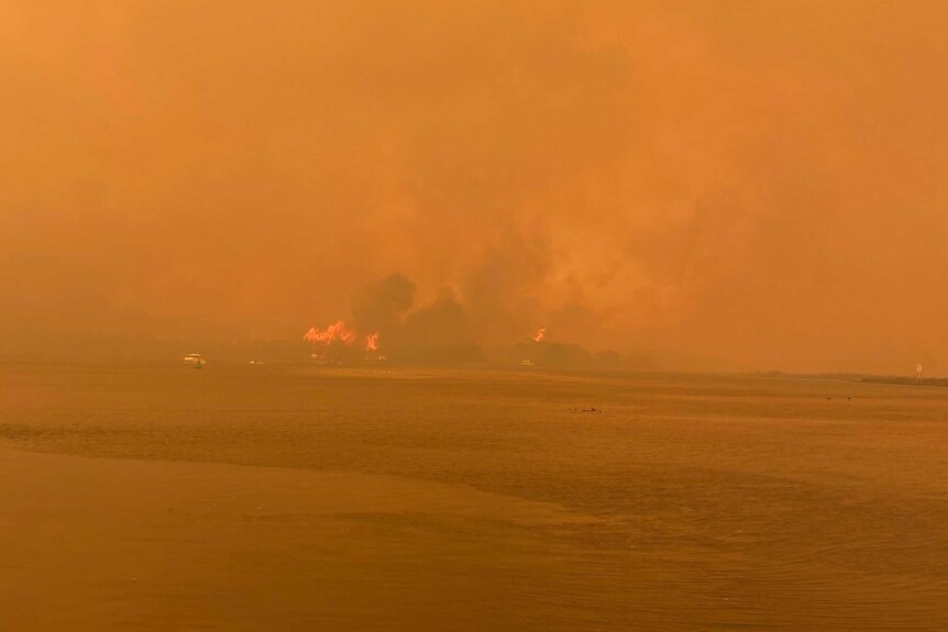 Fires burn across the bay in Mallacoota making the whole area orange.