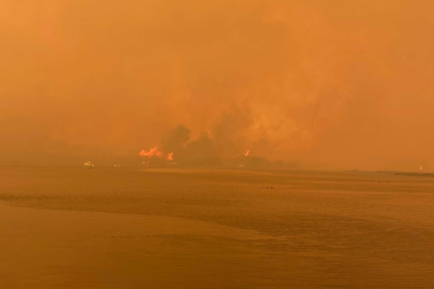 Fires burn across the bay in Mallacoota making the whole area orange.