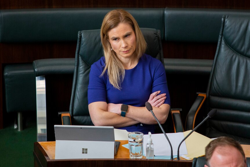  Kristie Johnston crosses her arms and looks angry while sitting in Parliament.