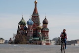 A man rides a bicycle along empty Red Square near St. Basil's Cathedral in central Moscow.
