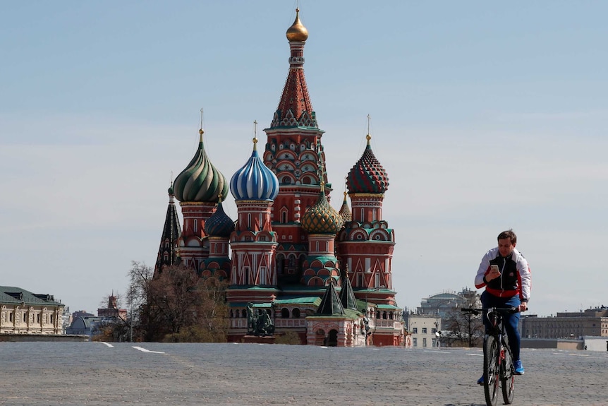 A man rides a bicycle along empty Red Square near St. Basil's Cathedral in central Moscow.