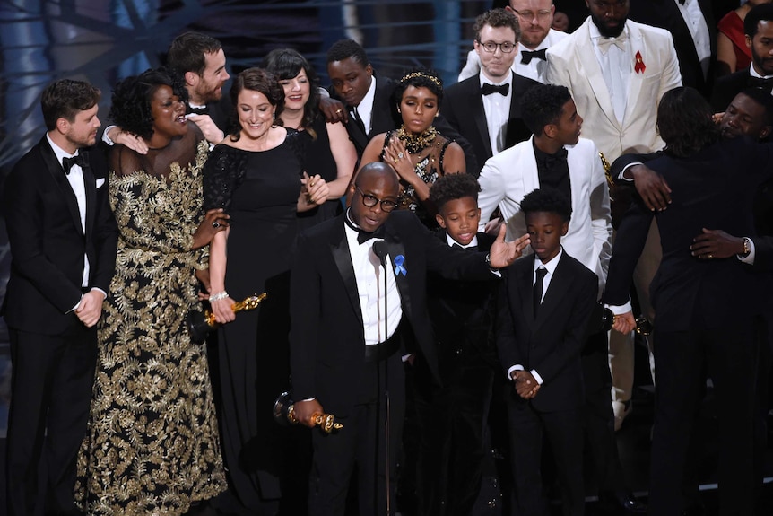 Barry Jenkins, foreground centre, and the cast accept the award for best picture for Moonlight at the Oscars.