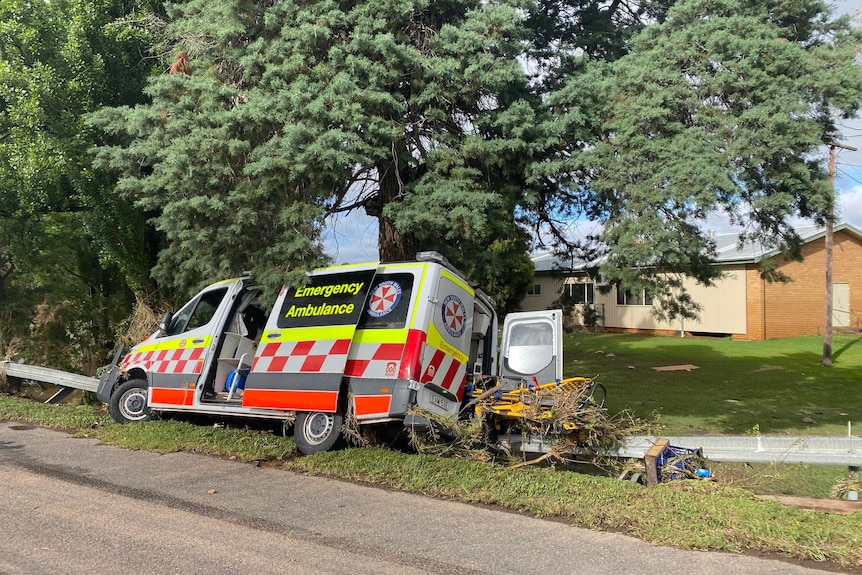 An amublance vehicle on its side after being hit by floodwater.