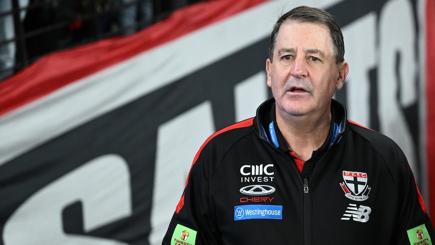 A picture of St Kilda AFL coach Ross Lyon standing on the sidelines at Docklands looking out on the field during a match.