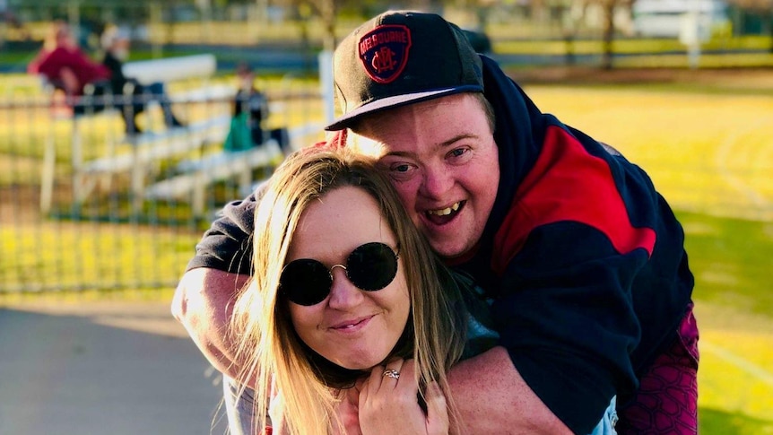 A man getting a piggyback on his sister's shoulders.