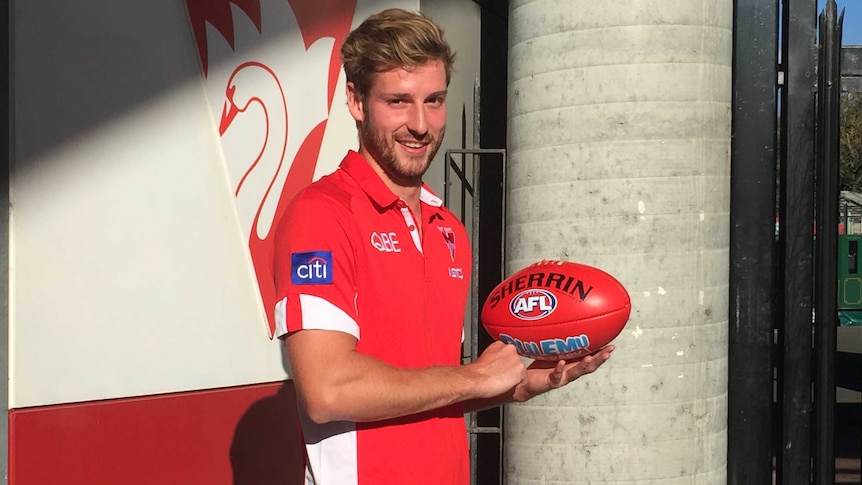 Sydney Swans defender Alex Johnson poses with a football on August 1, 2018.