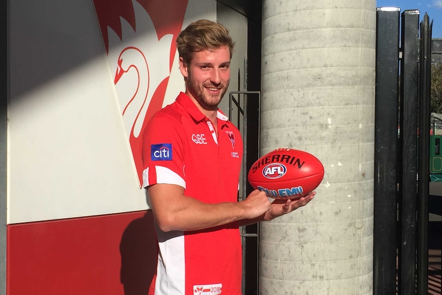 Sydney Swans defender Alex Johnson poses with a football on August 1, 2018.