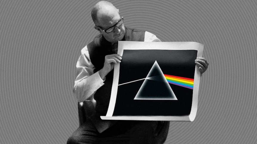An older gentleman holds up a screen print of Pink Floyd's Dark Side of the Moon artwork