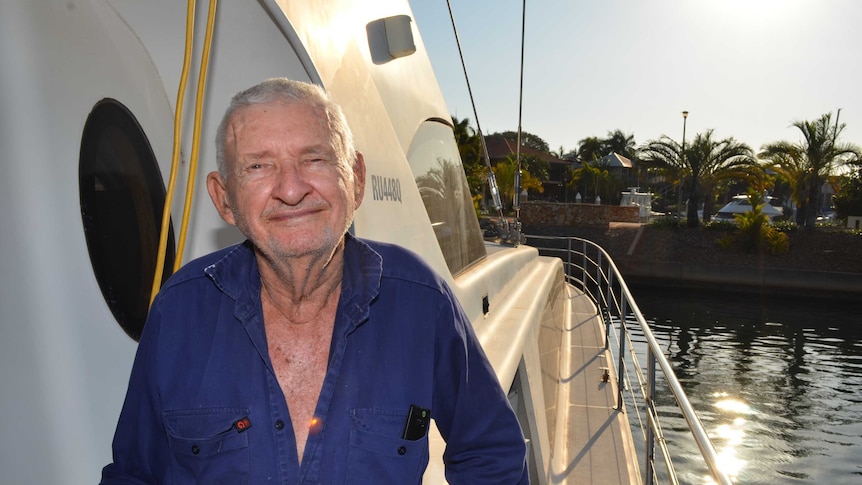 Paul Zlotkowski standing on his catamaran, with water on the right.