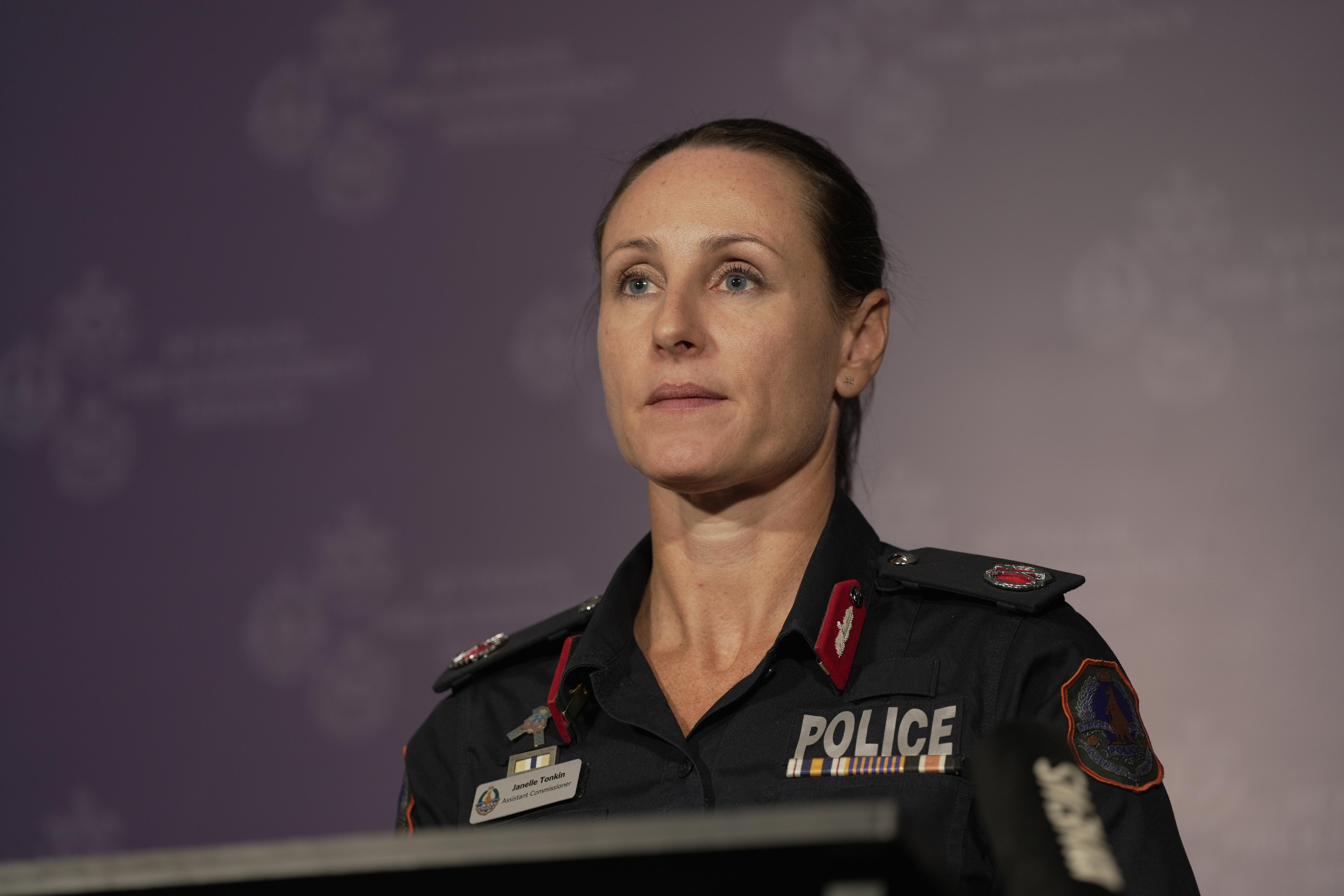 Janelle Tonkin, a woman with her hair tied back wearing a navy police uniform looks slightly to the right