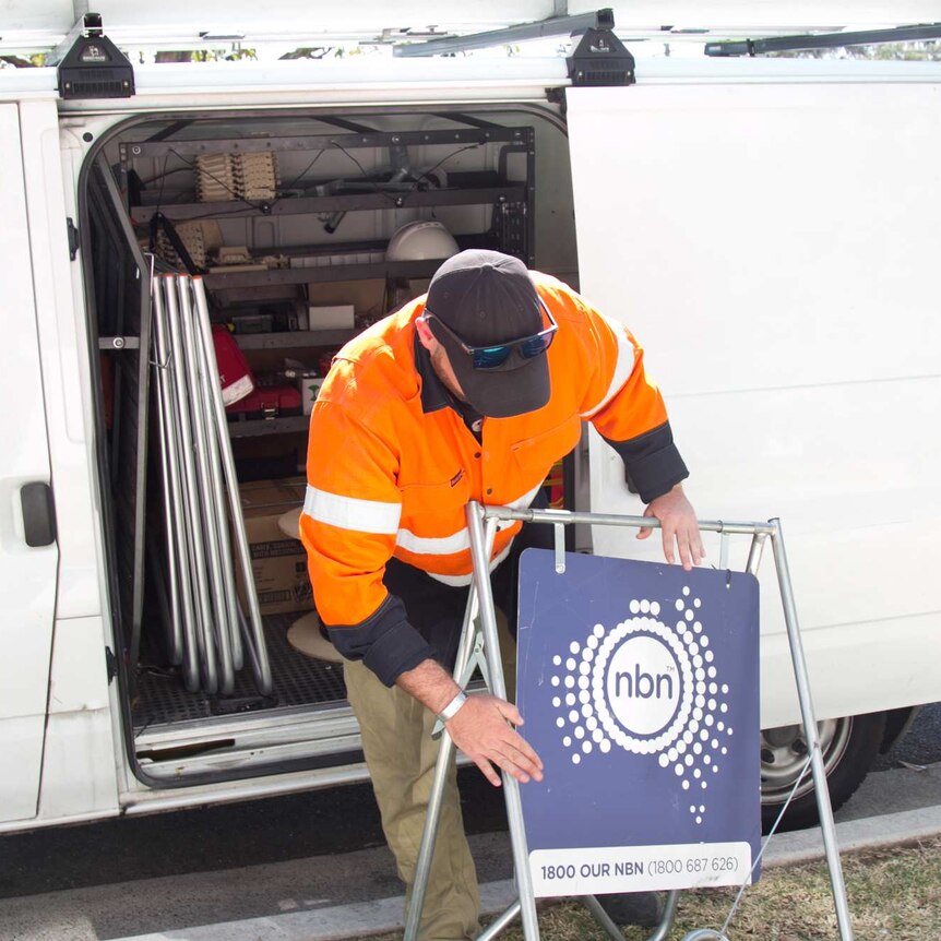 Michael Webeck packs away a sign displaying the NBN