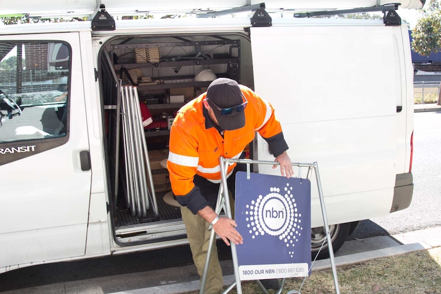 Michael Webeck packs away a sign displaying the NBN