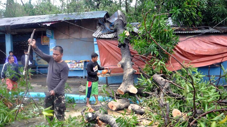 Philippines villages begin to clean up destruction from deadly typhoon, including fallen trees and destroyed buildings