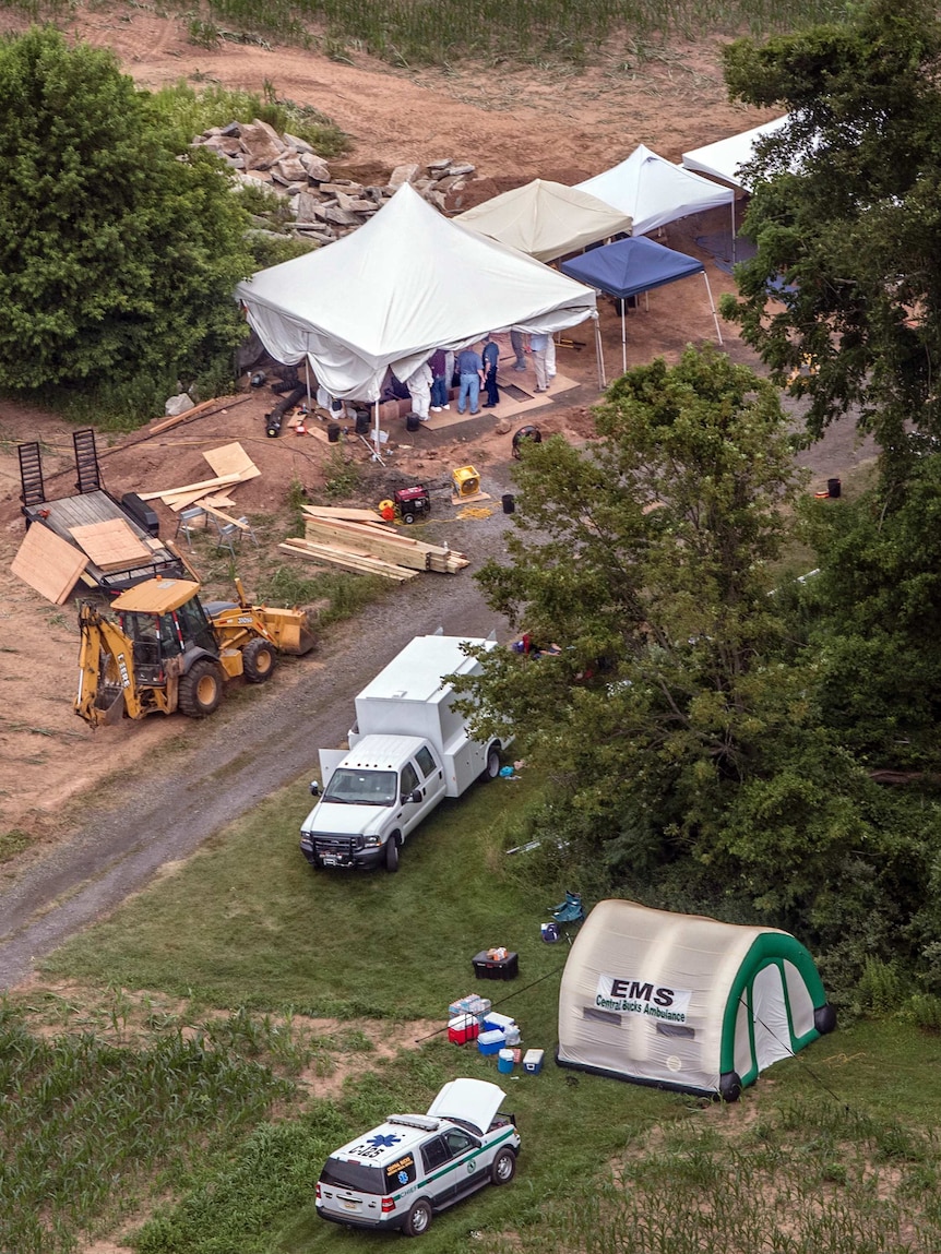 Investigators work under tents as they search for clues in the disappearance of four men in Solebury