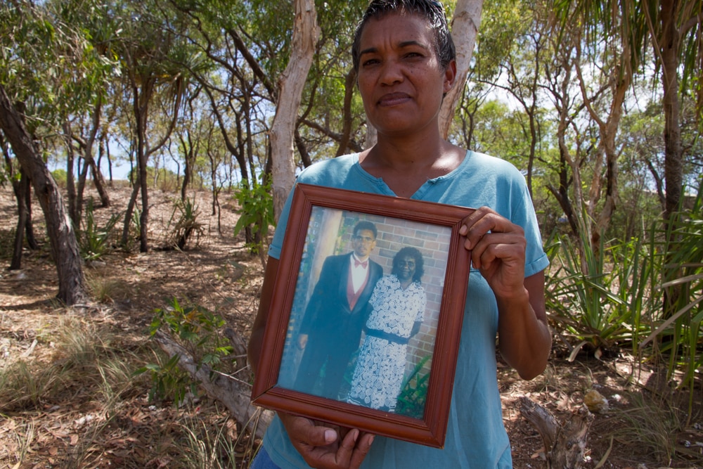 Coreen Reading holds up a picture of her brother and mother