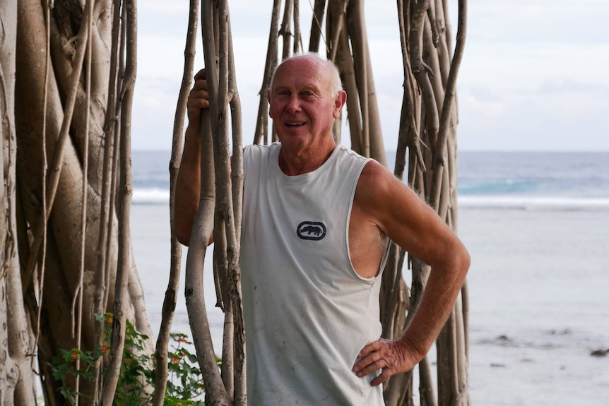 West Island resident graham Flynn poses beside a tree at the front of his property with the Indian Ocean in the background