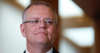 A man looks past the camera as he takes questions at a press conference