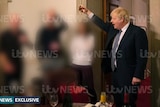 ITV-watermarked image shows four people intentionally blurred as a man in a suit with a white flop of hair raises his glass