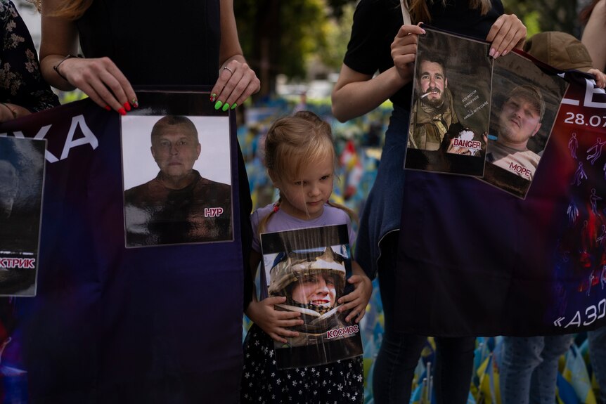 A girl holds a photo of a Ukrainian soldier, who was killed.