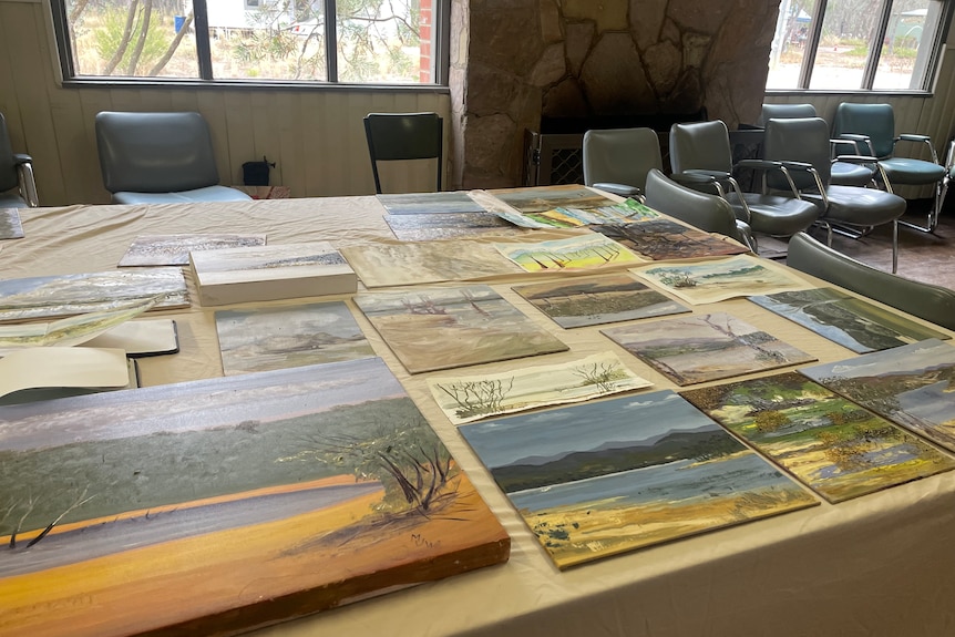 Table covered with paintings of the lake.
