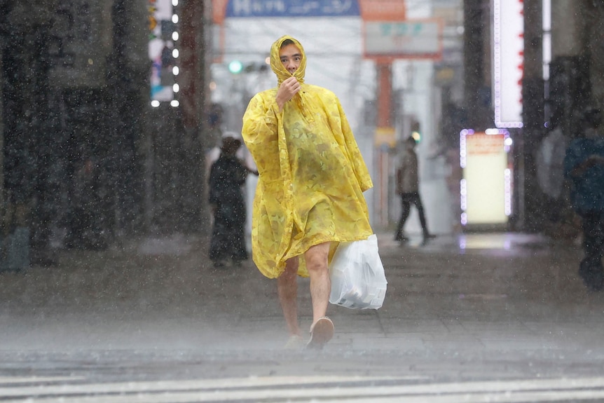 Un uomo che si fa strada sotto la pioggia battente