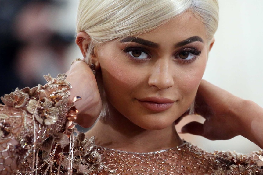 A close up of Ms Jenner with blond hair and nude sparkly dress.