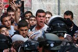 Palestinians shout in front of Israeli security forces who block a road leading to the Al-Aqsa mosque compound in Jerusalem's Old City