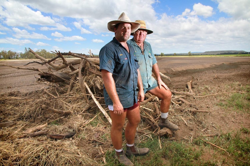 Jambin farmers Paul and John Heit in a paddock decimated by flood and cyclone.