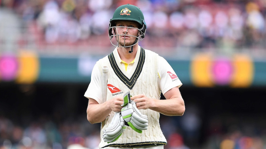 Cameron Bancroft takes his gloves off as he leaves the field on day one of the second Ashes Test at Adelaide Oval.