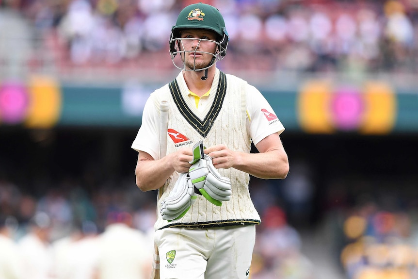 Cameron Bancroft takes his gloves off as he leaves the field on day one of the second Ashes Test at Adelaide Oval.