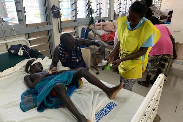 A patient lying on a hospital bed votes in the referendum.