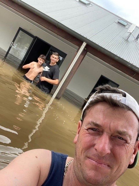 A man and two kids in floodwater.