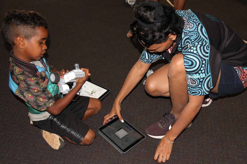 A young woman and a child with a robot