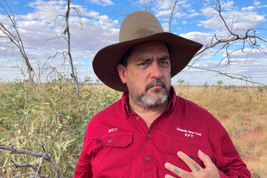 A photo of an Aboriginal man wearing a red shirt on in outback Australia