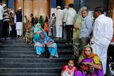 People queue outside a bank in India.