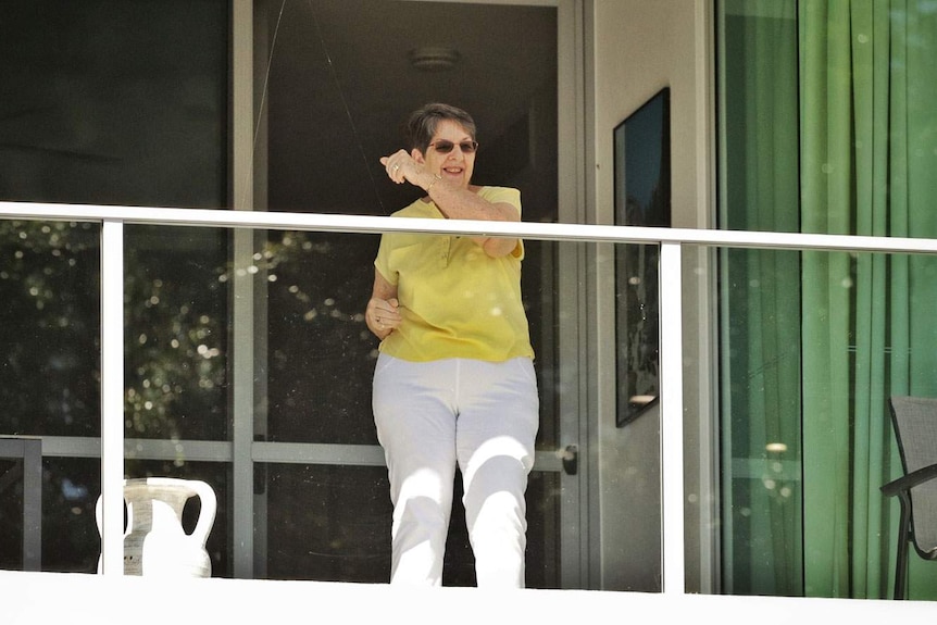 Elderly woman exercises on her balcony at Yeronga Retirement Village and Regis Aged Care in Brisbane.