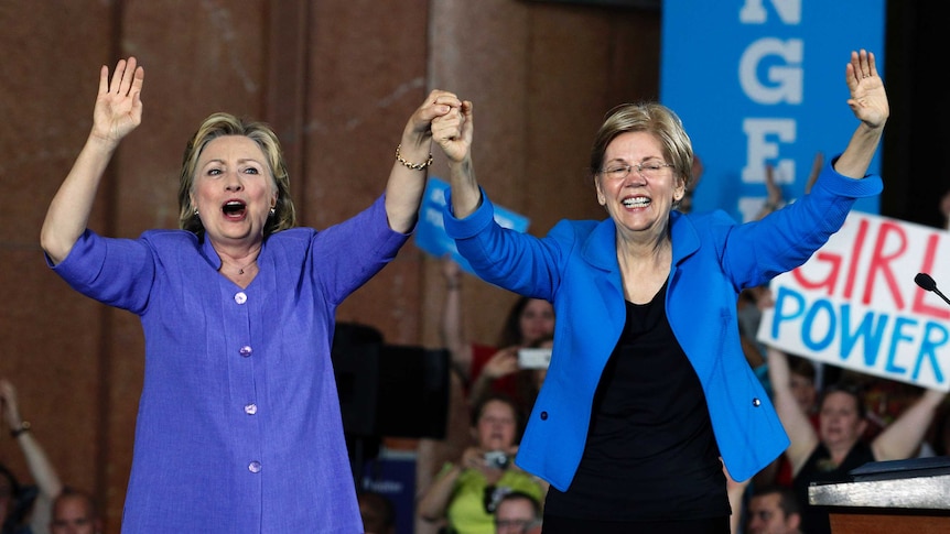 Hillary Clinton and Elizabeth Warren hold hands and cheer at a rally during the 2016 US presidential campaign.
