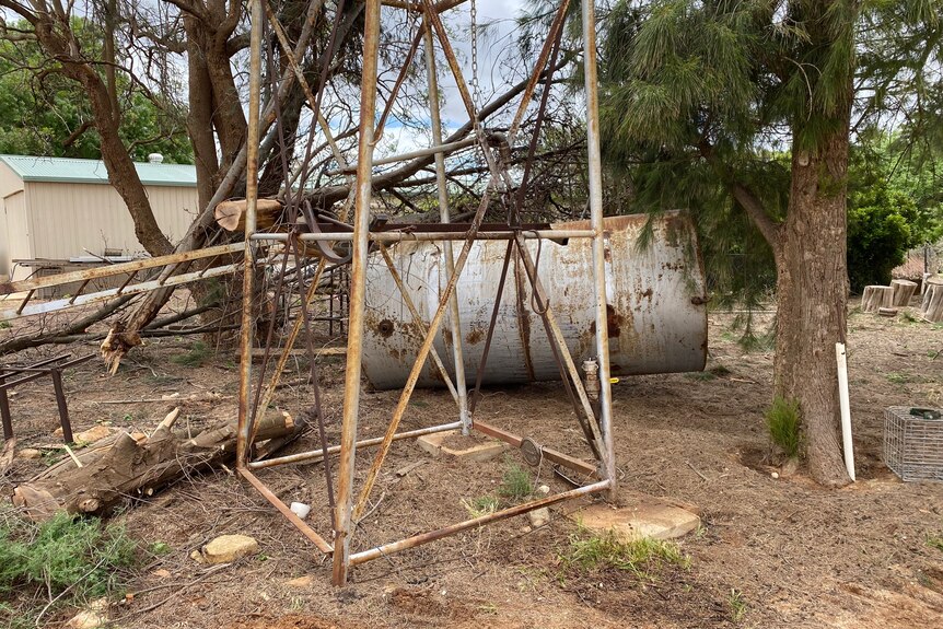 Tree Branches and a water tank on their side, after a storm damaged this agricultural property