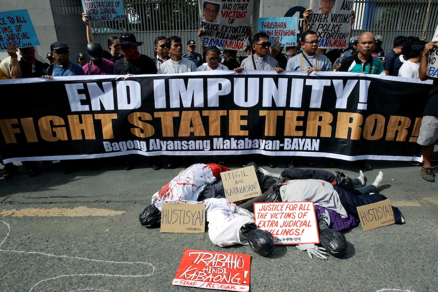 Activists protest using corpse effigies outside the police headquarters.