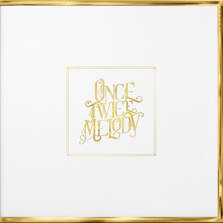 Once Twice Melody written in gold leaf lettering on a white background